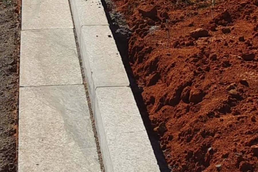 Granite kerbstones laid in a straight run along a road under construction